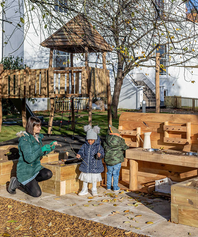 Nursery educator and children on a playground