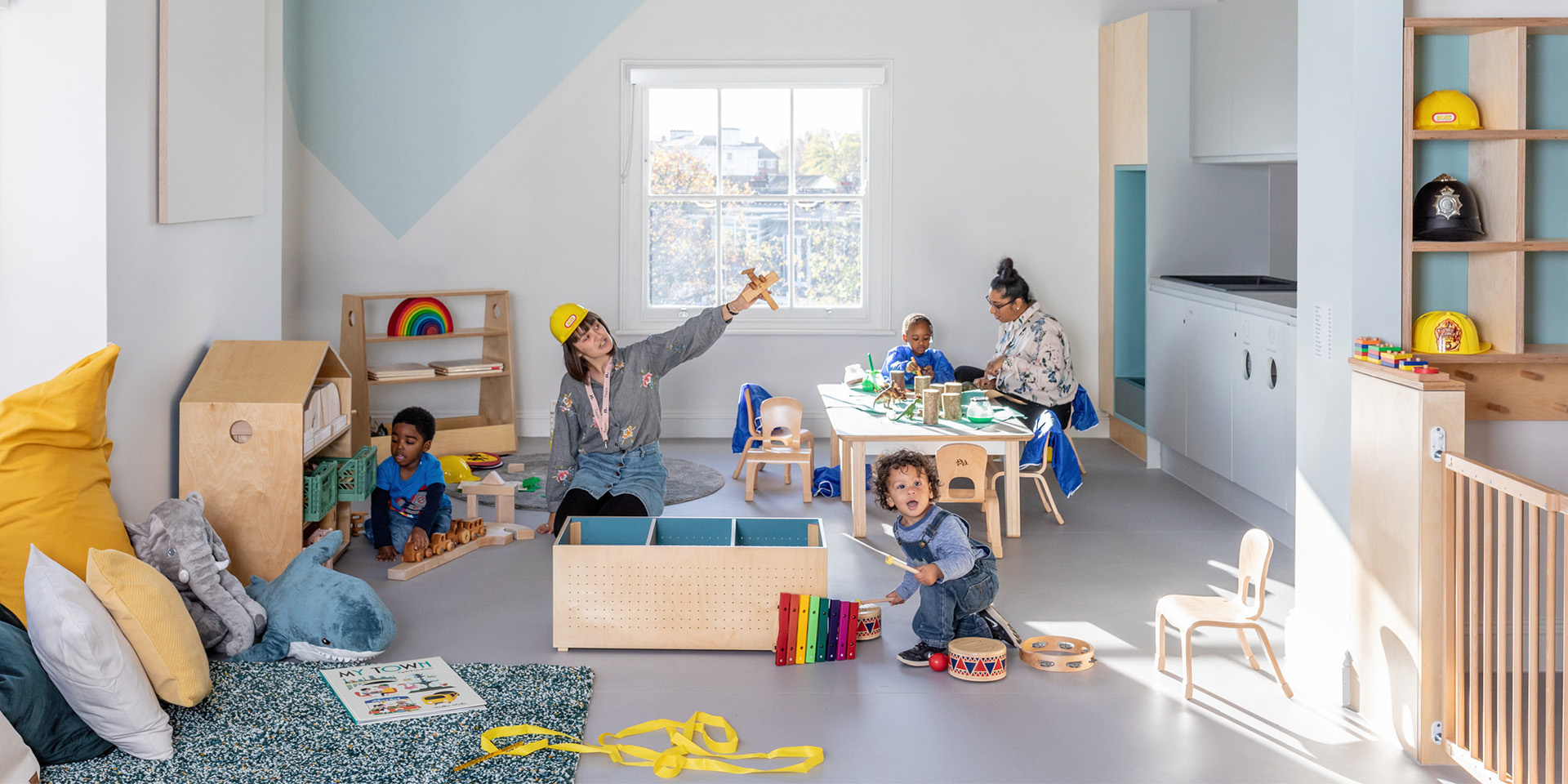 Nursery educators and children playing