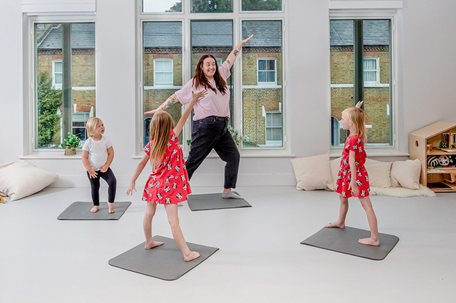 Nursery educator and children doing yoga