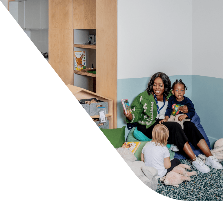 A nursery educator and children reading a book