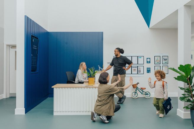 N nursery reception: team members talking and an educator greeting a child