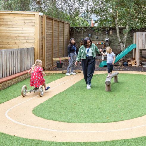 Educators and children playing in the nursery garden