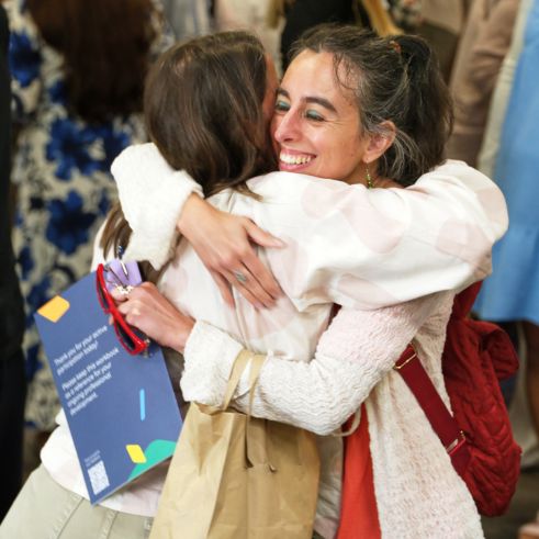A girl hugging a team member and smiling