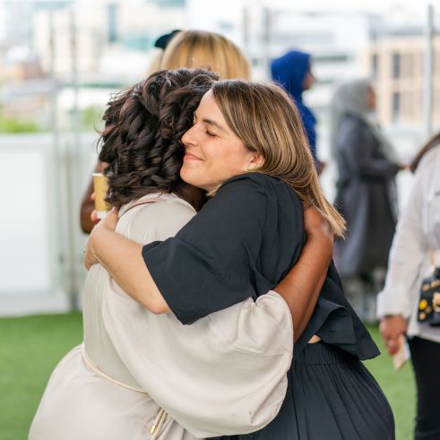 Two team members hugging at the summer get together