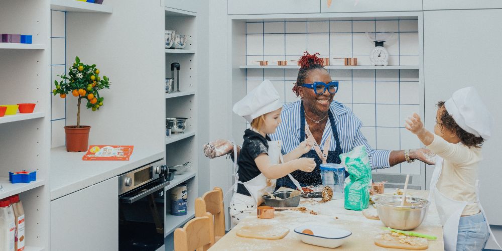 An educator and two children playing in a nursery atelier